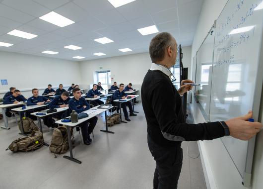 Professeur donnant cours devant une classe d'élèves