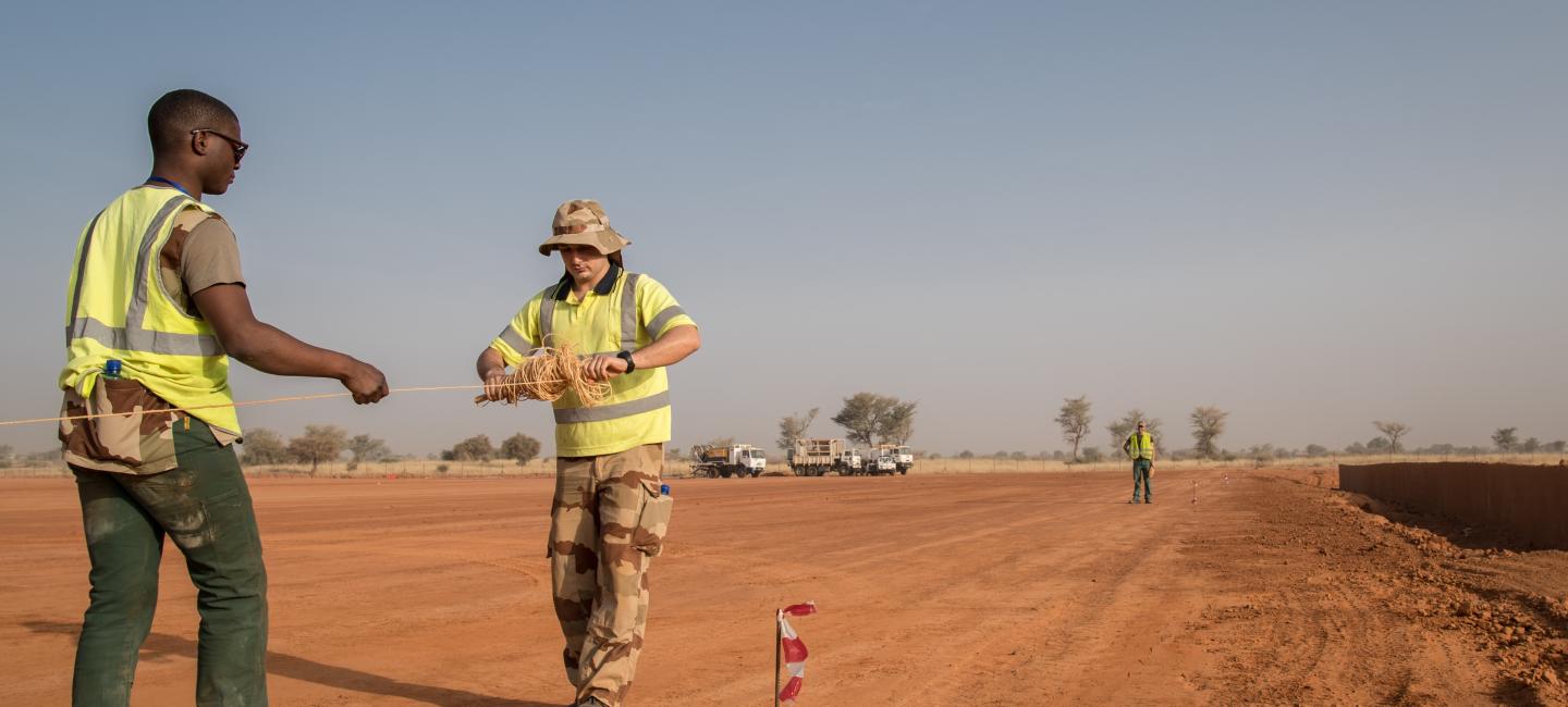 Officier sous contrat déroulant un câble sur un terrain militaire