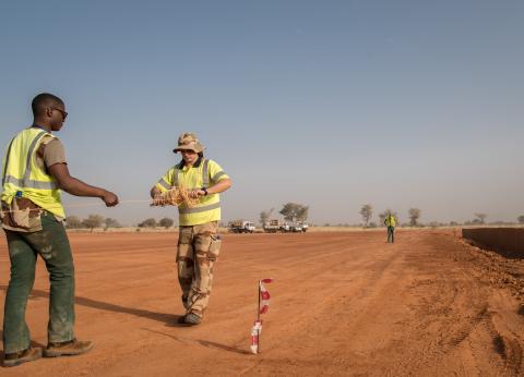 Officier sous contrat déroulant un câble sur un terrain militaire